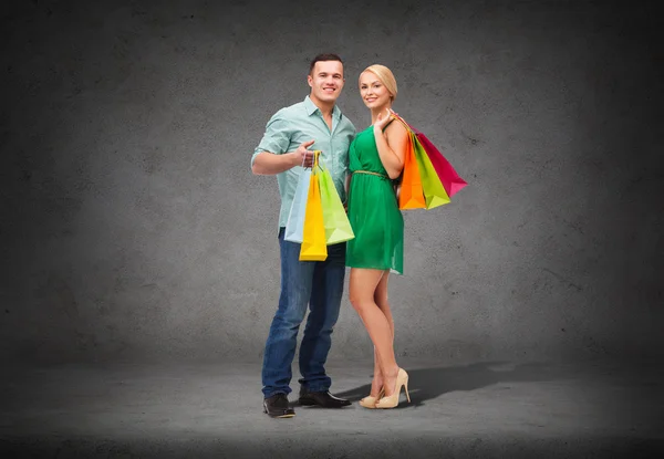 Coppia sorridente con shopping bags — Foto Stock