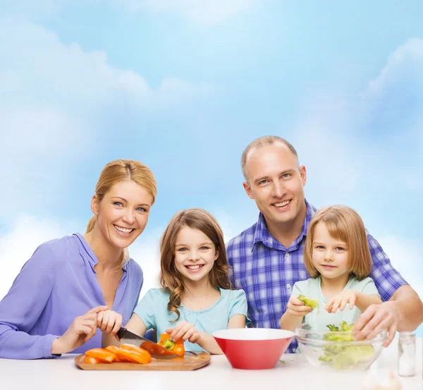 Família feliz com dois filhos fazendo o jantar em casa — Fotografia de Stock