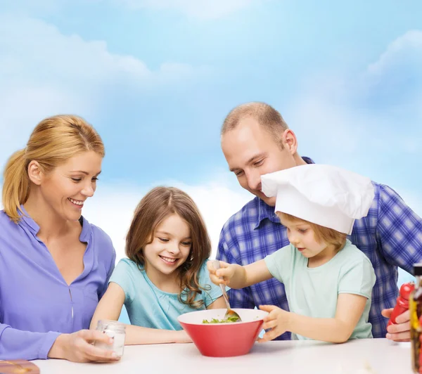 Ευτυχισμένη οικογένεια με δύο παιδιά, φαγητό στο σπίτι — Φωτογραφία Αρχείου