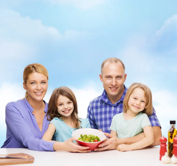 Gelukkig gezin met twee kinderen met salade thuis — Stockfoto