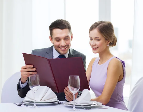 Coppia sorridente con menù al ristorante — Foto Stock
