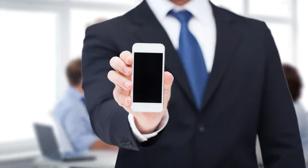 Empresario mostrando smartphone con pantalla en blanco — Foto de Stock