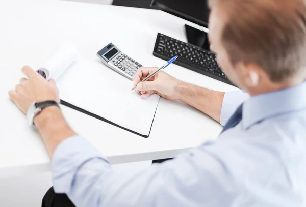 Empresario con cuaderno y calculadora —  Fotos de Stock