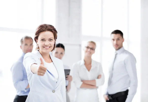Businesswoman in office showing thumbs up — Stock Photo, Image