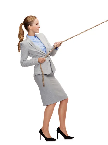 Smiling businesswoman pulling rope — Stock Photo, Image