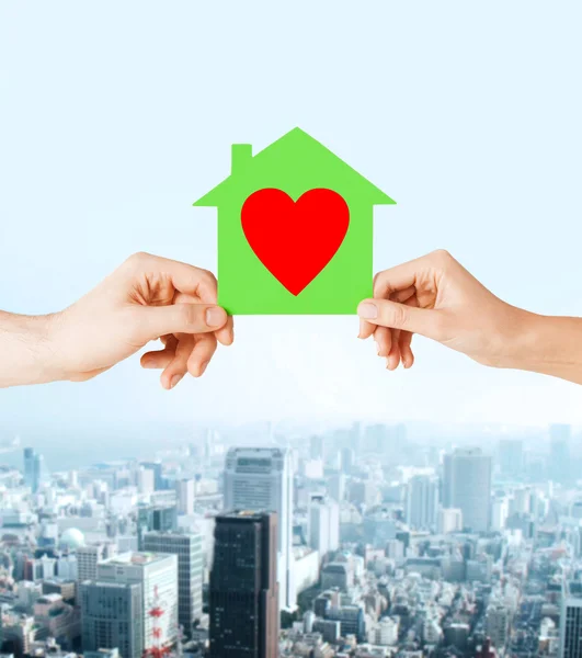 Couple hands holding green paper house — Stock Photo, Image