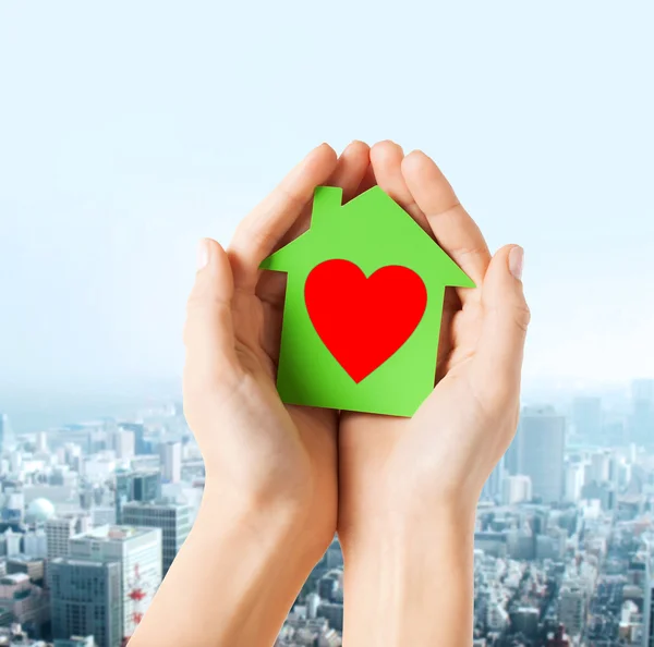 Ruce drží zelený papír dům — Stock fotografie