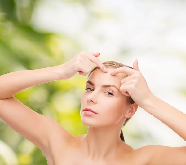 Jonge vrouw knijpen acne vlekken — Stockfoto