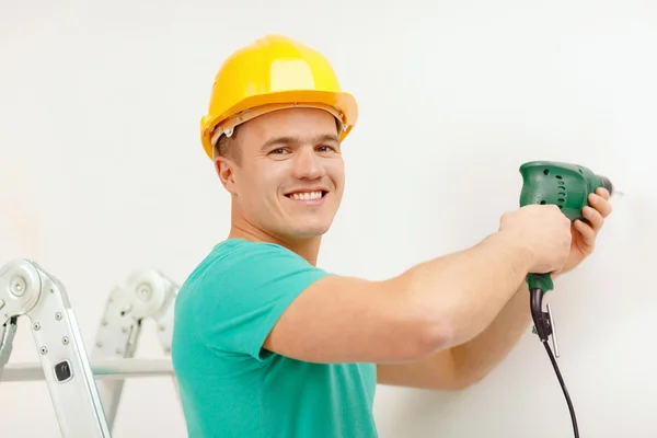 Man with electric drill making hole in wall — Stock Photo, Image