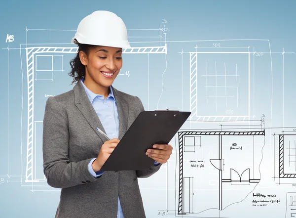 Businesswoman in white helmet with clipboard — Stock Photo, Image