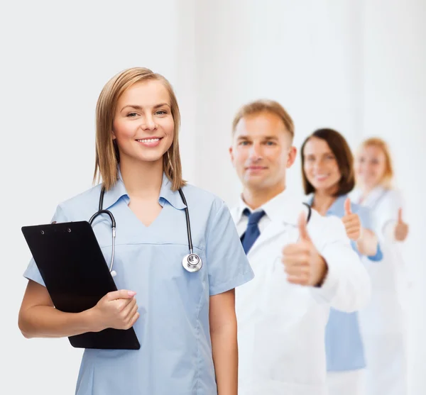 Médico o enfermera sonriente con portapapeles —  Fotos de Stock