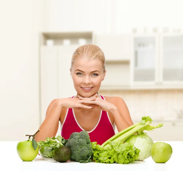 Sorrindo mulher desportiva com alimentos orgânicos — Fotografia de Stock