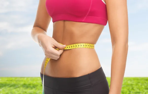 Close up of trained belly with measuring tape — Stock Photo, Image