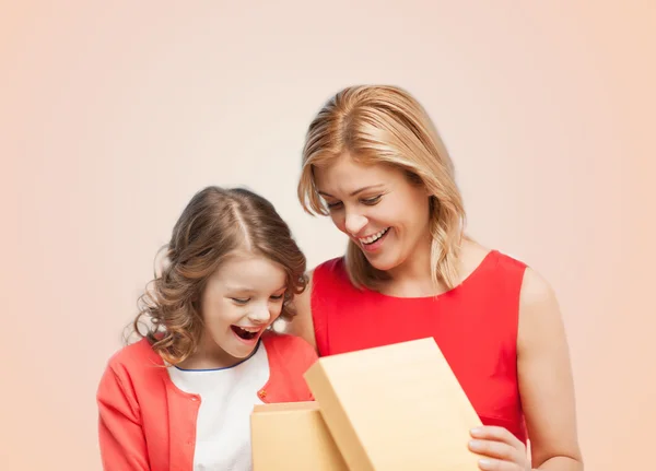 Sorrindo mãe e filha com caixa de abertura gisft — Fotografia de Stock