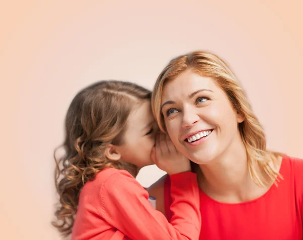 Smiling mother and daughter whispering gossip — Stock Photo, Image