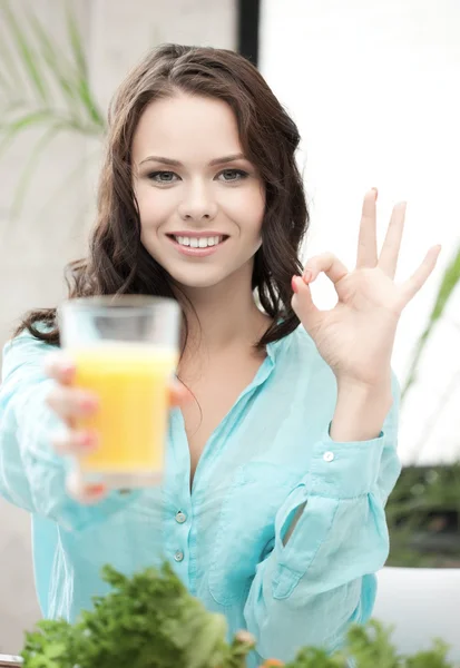 Donna con vetro di succo d'arancia che mostra segno ok — Foto Stock