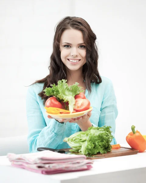 Schöne Frau in der Küche Gemüse schneiden — Stockfoto