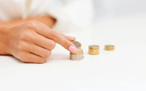 Mano femminile che mette le monete in euro in colonne — Foto Stock