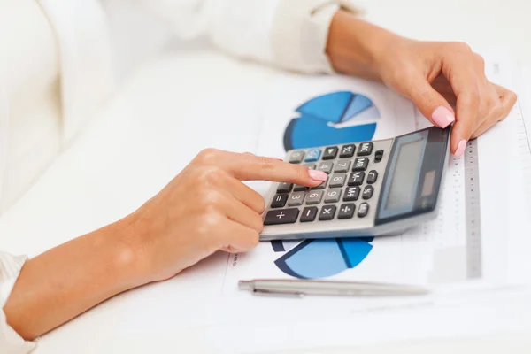 Geschäftsfrau arbeitet mit Taschenrechner im Büro — Stockfoto