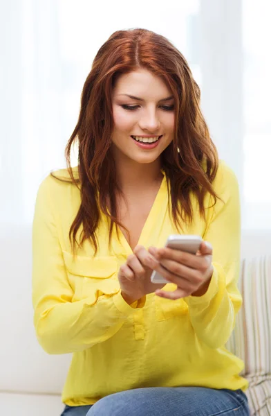 Mujer sonriente con smartphone en casa —  Fotos de Stock