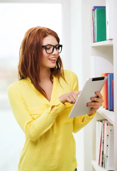 Sorrindo Estudante feminina com tablet pc na biblioteca — Fotografia de Stock