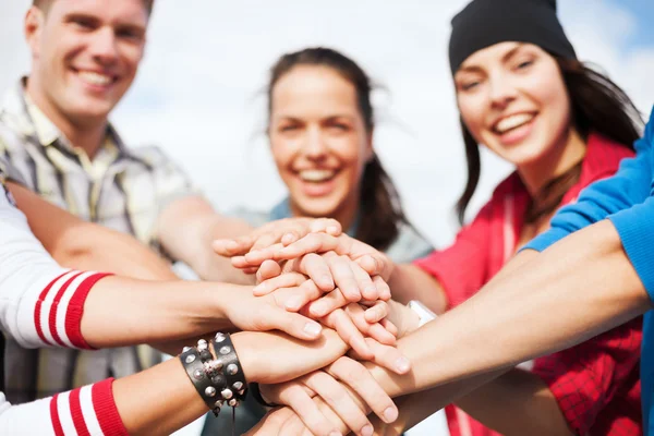 Teenagers hands on top of each other outdoors — Stock Photo, Image