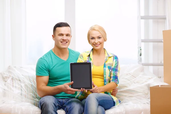 Pareja relajante en el sofá con la tableta de la PC en el nuevo hogar —  Fotos de Stock