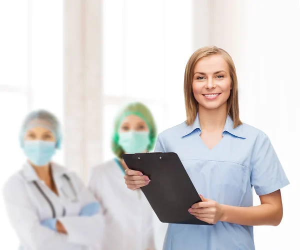 Médecin ou infirmière souriante avec presse-papiers — Photo