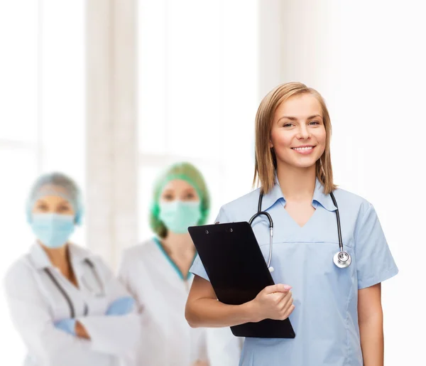 Médico o enfermera sonriente con portapapeles — Foto de Stock