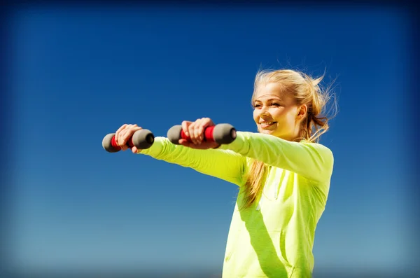 Sporty woman with light dumbbells outdoors — Stock Photo, Image