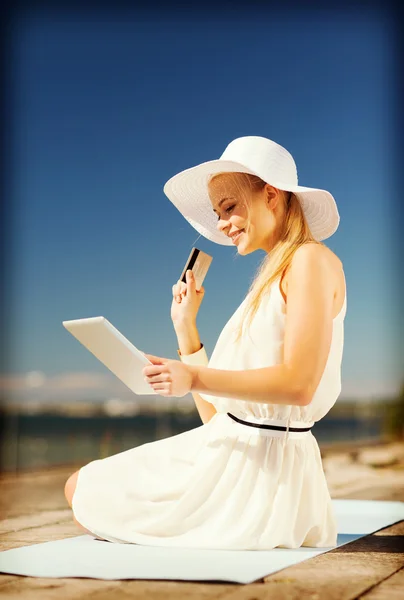 Woman in hat doing online shopping outdoors — Stock Photo, Image