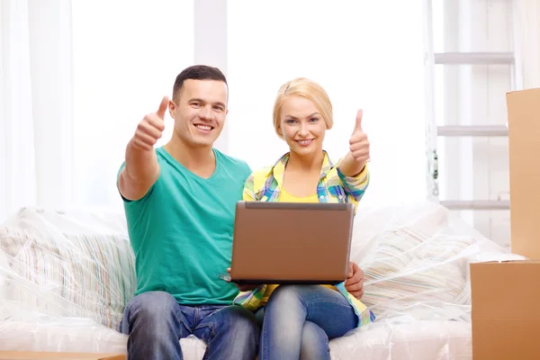 Para relaksujący na kanapie z laptopem w nowym domu — Zdjęcie stockowe