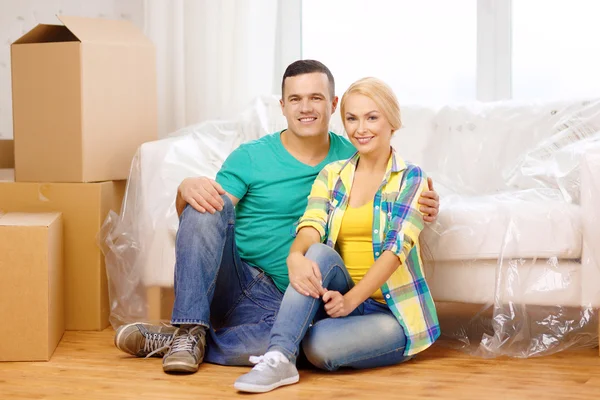 Smiling couple sitting on the floor in new house — Stock Photo, Image