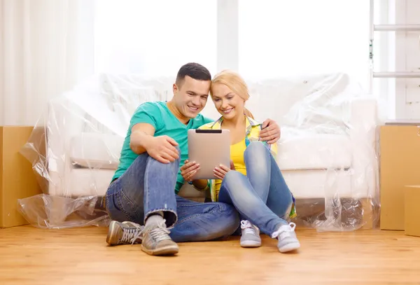 Улыбающаяся пара с планшетным ПК в новом доме — стоковое фото