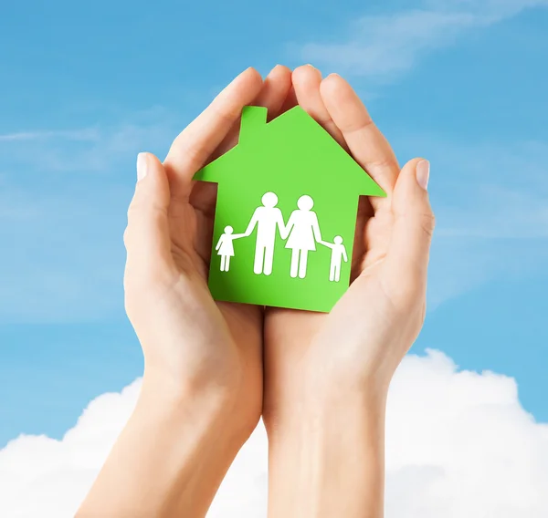 Zielony dom z rodziny trzymając się za ręce — Zdjęcie stockowe