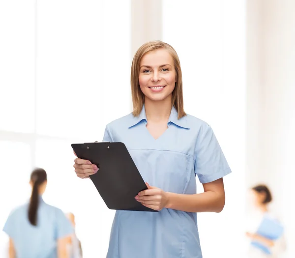 Médico o enfermera sonriente con portapapeles —  Fotos de Stock