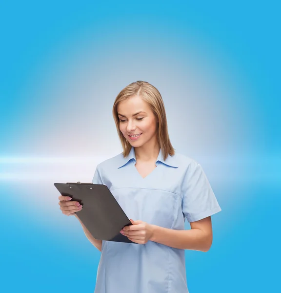 Smiling female doctor or nurse with clipboard — Stock Photo, Image