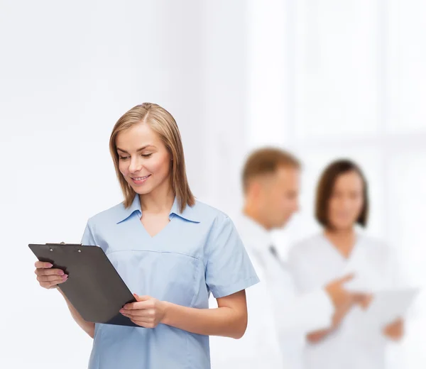 Médico o enfermera sonriente con portapapeles —  Fotos de Stock