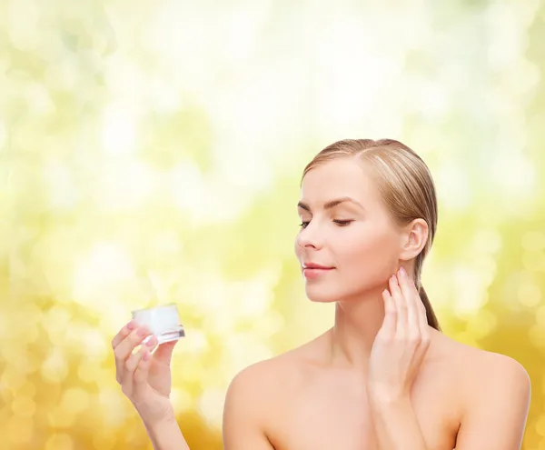 Woman applying cream on her skin