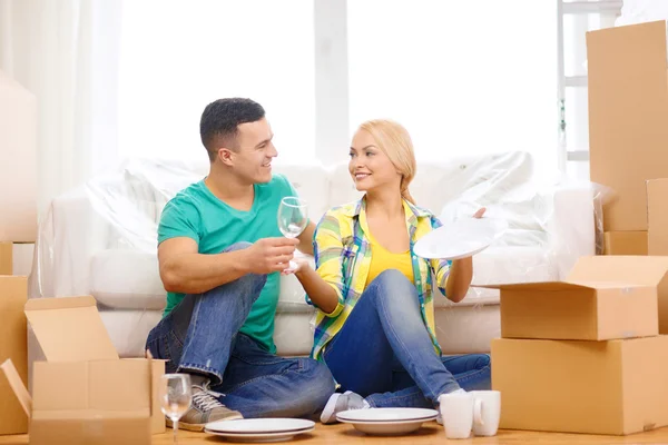 Pareja sonriente desempacadoras con utensilios de cocina — Foto de Stock