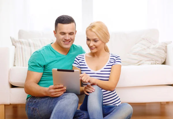 Souriant couple heureux avec tablette PC à la maison — Photo