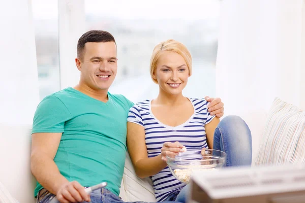 Coppia sorridente con popcorn guardando film a casa — Foto Stock