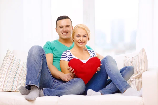 Sonriendo feliz pareja con el corazón rojo en casa — Foto de Stock