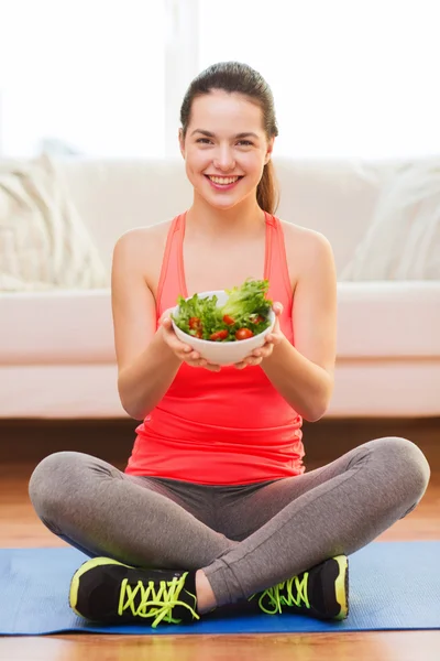 Sorrindo adolescente com salada verde em casa — Fotografia de Stock