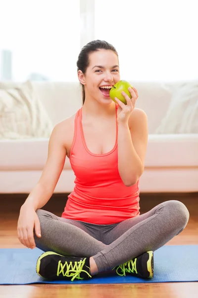 Lächelndes Teenager-Mädchen mit grünem Apfel zu Hause — Stockfoto