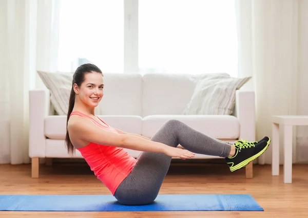 Sorrindo menina fazendo exercício no chão em casa — Fotografia de Stock