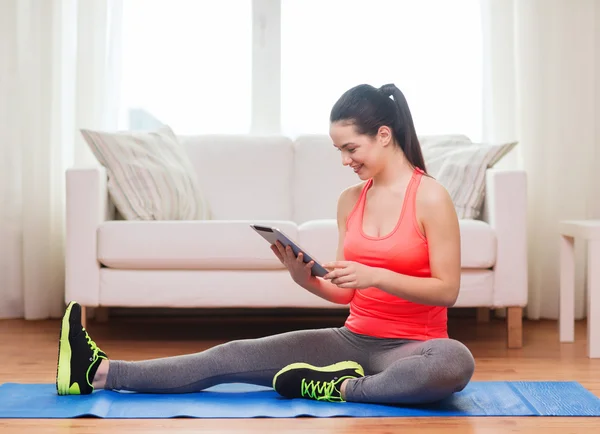 Smiling teenage girl streching on floor at home — Stock Photo, Image