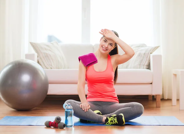 Smiling girl with bottle of water after exercising — Stock Photo, Image