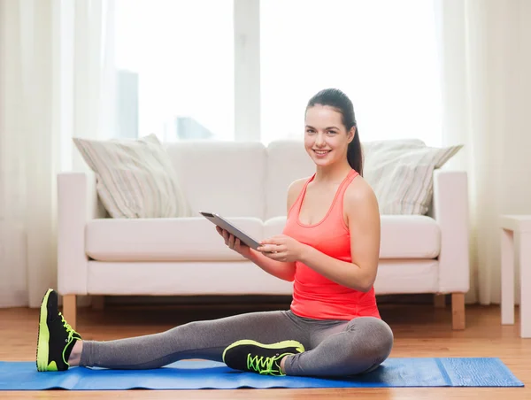 Smiling teenage girl streching on floor at home — Stock Photo, Image