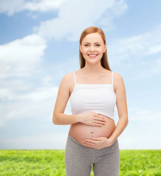 Glückliche zukünftige Mutter, die ihren Bauch berührt — Stockfoto